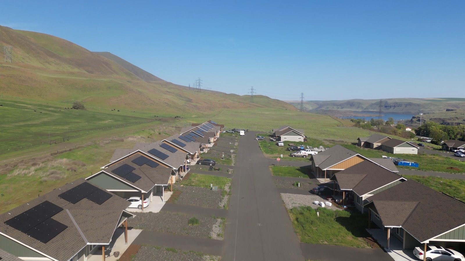 Aerial view of a Tribal housing community with rooftop solar panels in a river valley